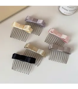 Dettaglio di eleganti pettini per capelli in raso in cinque colori con denti metallici