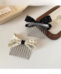 Detailed view of polka dot bow hair combs with sturdy metal teeth on a wooden tray