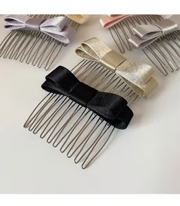 Dettaglio di pettini per capelli con fiocco in raso colorato e denti in metallo