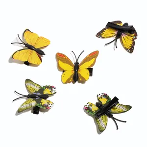 Detailed view of five colorful butterfly hair clips with black alligator clips on white base