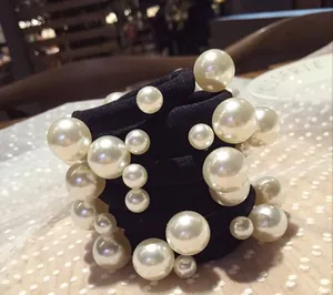Dettaglio di set elastici per capelli con perle finte bianche su pizzo elegante