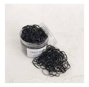 Détail d'élastiques à cheveux noirs haute élasticité dans un bocal transparent