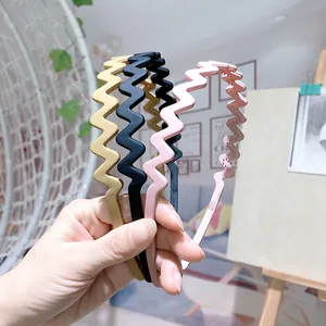 Detail of matte wavy headbands with non-slip teeth in khaki, black, and light pink