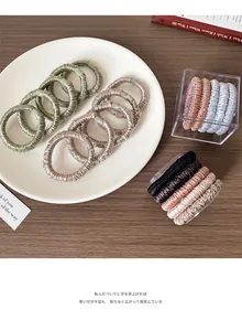 Detailed view of Morandi-toned satin scrunchies with pleated texture and high elasticity