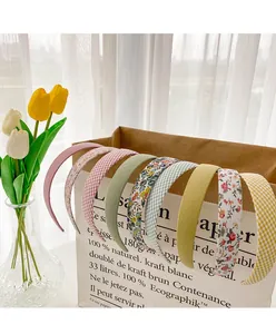 Close-up of assorted vintage floral and plaid fabric headbands on a paper gift bag