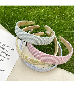 Close-up of vintage gingham fabric headbands in pastel colors on natural grass