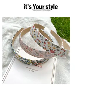 Detailed view of floral fabric headbands in white, pink, and blue on natural grass