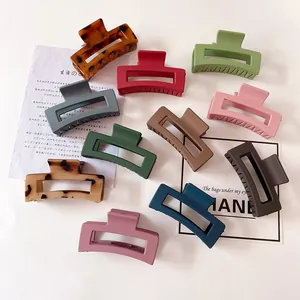 Macro shot of assorted matte resin hair clips in various colors with geometric cutouts