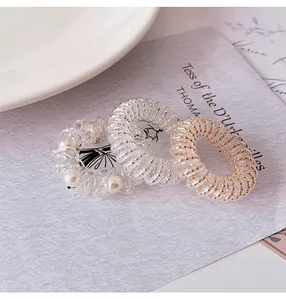 Three-piece set of transparent telephone wire hair ties with faux pearls and gold wire details