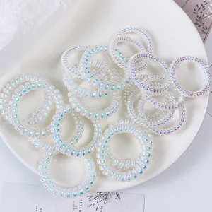 Set di elastici per capelli a spirale bianchi iridescenti in un vassoio bianco pulito