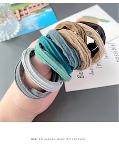 Close-up of high-elasticity fabric hair ties in assorted Morandi colors held by hand
