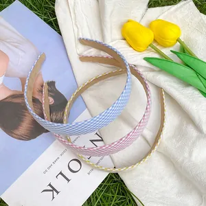 Three vintage plaid headbands in blue, pink, and yellow fabric on a green lawn