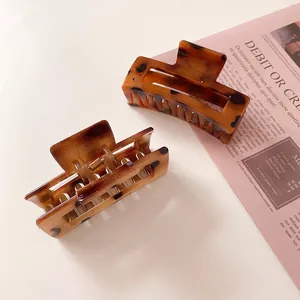 Close-up of elegant amber tortoise shell hair clips set on a stylish beige background