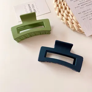 Close-up of matte geometric hair clips in matcha green and navy blue colors