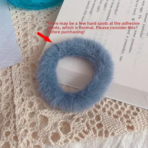 Detail view of the blue faux rabbit fur hair tie showing the adhesive joint craftsmanship