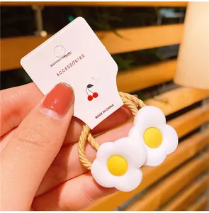 Dettaglio di elastico per capelli giallo con due fiori 3D bianchi per bambine piccole