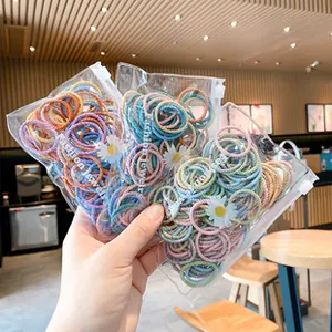 Primer plano de gomas de pelo coloridas en bolsas con estampado de margaritas