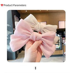Detail von rosa und cremeweißen Oversize-Satinschleifen-Haarspangen mit elegantem Perlglanz