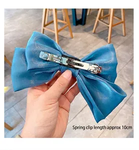 Detail eines 10 cm langen Metall-Federclips an einer himmelblauen Satin-Haarschleife