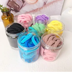 Détail de chouchous côtelés colorés en pots transparents pour un style organisé