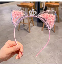 Nahaufnahme von rosa Katzenohren-Haarreif mit funkelnden Pailletten und Silberkrone