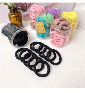 Détail d'élastiques à cheveux sans couture aux couleurs bonbon dans un pot transparent