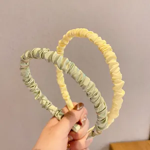 Pleated satin headbands in cream yellow and light green with soft scrunchie texture