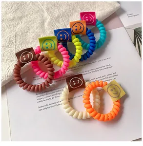 Dettaglio di elastici per capelli a spirale colorati con etichette sorriso su una rivista