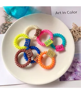 Dettaglio di elastici per capelli a spirale colorati con etichette a forma di smiley
