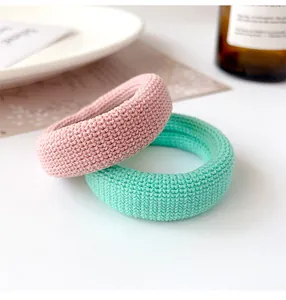 Detail of high-elastic pink and mint green knitted hair ties with ribbed texture