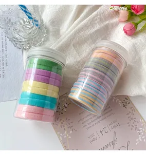 Detail of high-elasticity seamless hair ties in a clear bottle with pastel colors