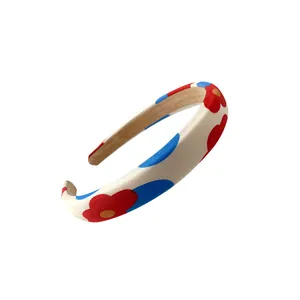 Serre-tête en tissu à fleurs rouges et pois bleus sur base en éponge blanc cassé