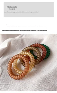 Close-up of matte resin spiral hair ties in earth tones set on textured linen fabric