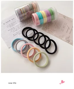 Macro detail of elastic seamless hair ties in macaron colors with cylindrical storage tube