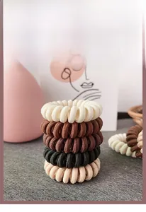 Détail d'élastiques à cheveux spirale en tons terreux avec une grande élasticité