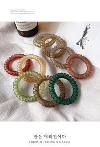 Detail of durable matte spiral hair ties in retro earthy colors on cotton background