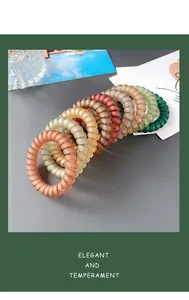 Macro view of matte spiral hair ties in various vintage earth tones with elegant texture