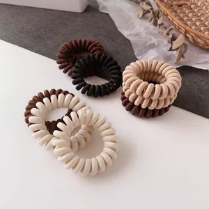 Élastiques à cheveux spirales tons terre sur fond esthétique et rustique
