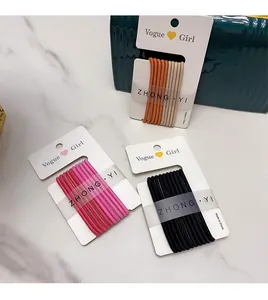 Close-up of high-elasticity hair ties in orange, pink, and black sets on display cards