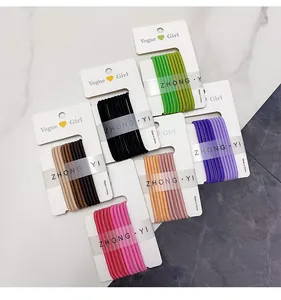 Bulk set of candy-colored elastic hair ties on display cards with marble background