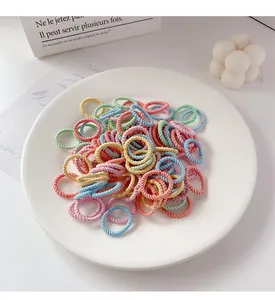 Detalle macro de gomas de pelo en espiral de colores en un plato de cerámica blanca