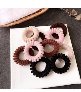 Dettaglio di elastici a spirale in velluto nei colori Morandi con texture morbida e setosa
