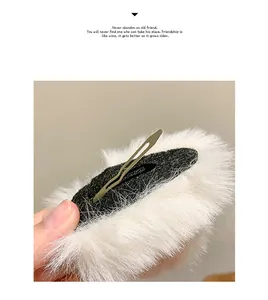 Close-up of the metal clip back and white faux fur texture on cat ear hairpins