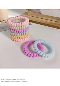 Detail of candy-colored spiral hair ties in macaron tones with high-elasticity matte finish