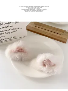 Close-up of plush cat ear hair clips in soft off-white with fluffy faux fur texture