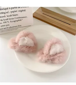 Close-up of fluffy pink and white plush cat ear hair clips on a decorative tray