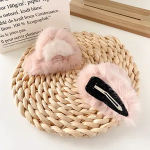 Plush pink cat ear hair clips on a woven mat, cute faux fur hair accessories for women
