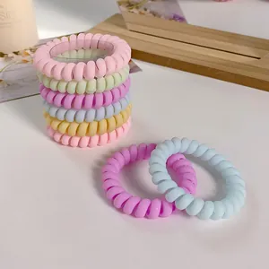 Pastel spiral hair ties in macaron colors stacked on a wooden tray set of 9 pieces