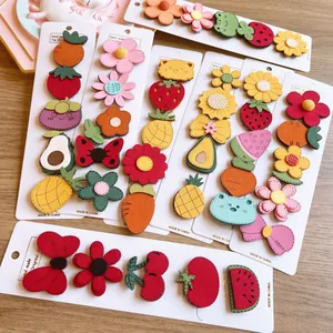 Detailed view of colorful cartoon fruit and animal felt velcro hair clips for kids