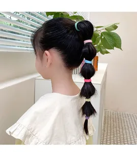 Detail of colorful elastic hair bands used for styling bubble braids on a child hair